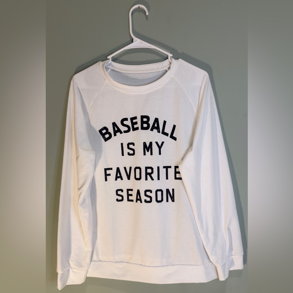 White sweatshirt with black‎ writing. Baseball mom life.